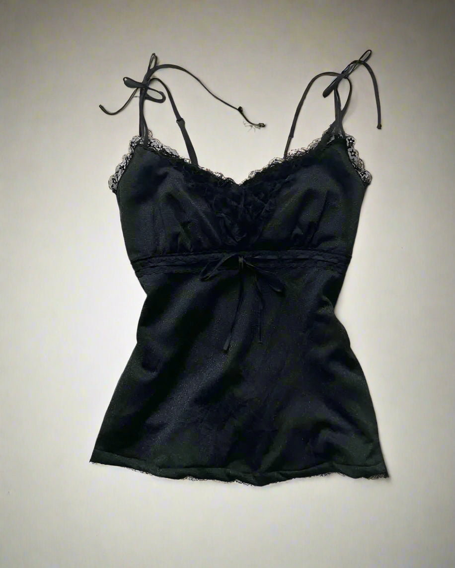 Black lace camisole with shoes and accessories on a light gray surface