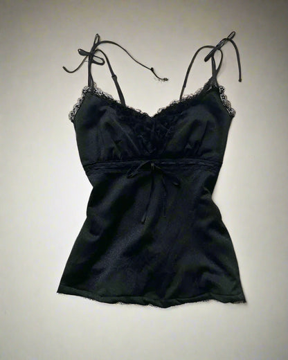 Black lace camisole with shoes and accessories on a light gray surface
