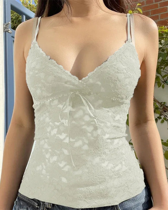 Woman wearing a light green lace camisole with a blurred background