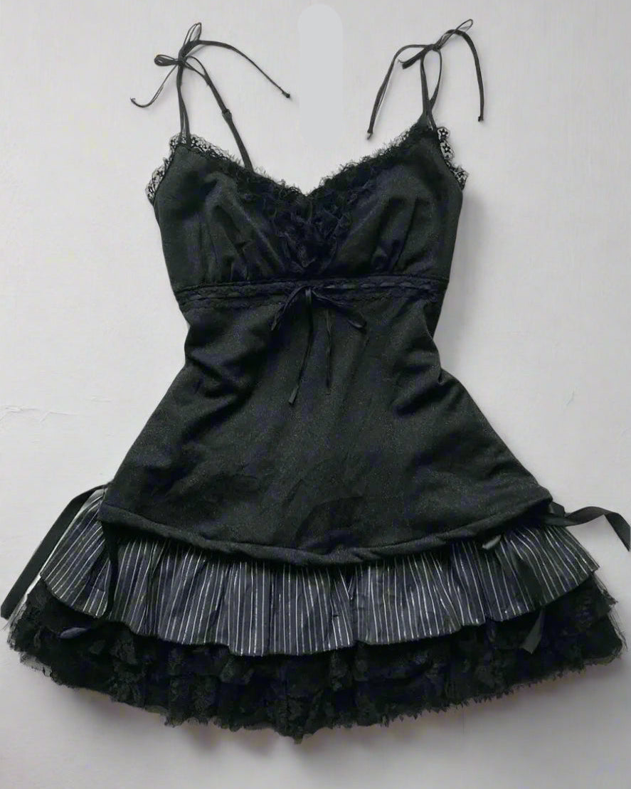 Black lace dress with accessories on a textured surface