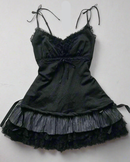 Black lace dress with accessories on a textured surface