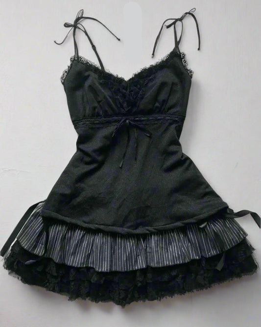 Black lace dress with accessories on a textured surface